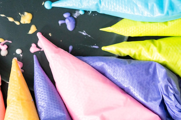 Close up. colorful piping bags with royal ising on the table