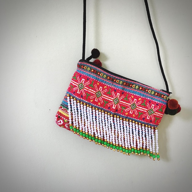 Photo close-up of colorful purse hanging on wall