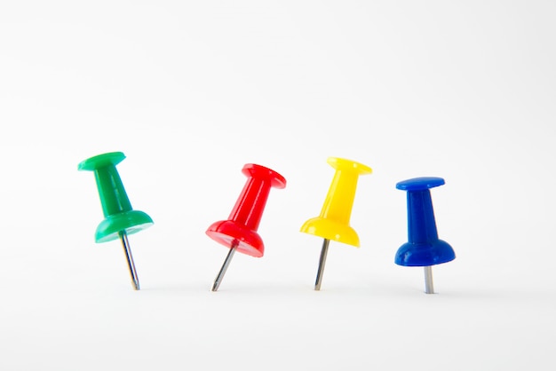 Close up colorful thumbtack with green, red, yellow and blue isolated on white 