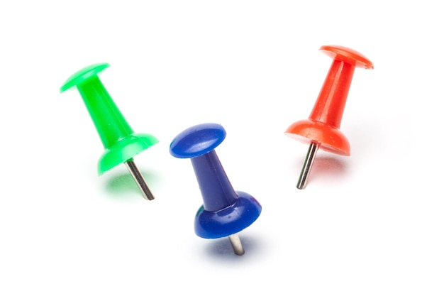 Photo close-up of colorful thumbtacks against white background