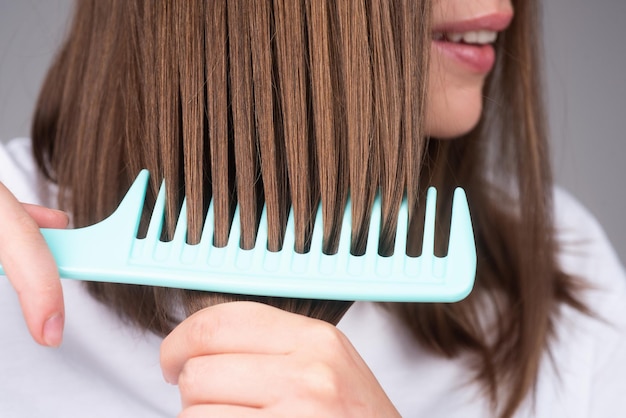 Primo piano che pettina capelli sani e lucenti isolati su studio