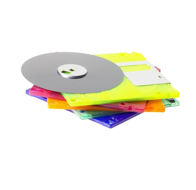 Photo close-up of compact disk with multi colored cd cases on white background