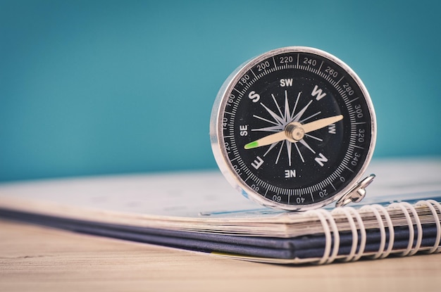 Photo close-up of compass and book on table