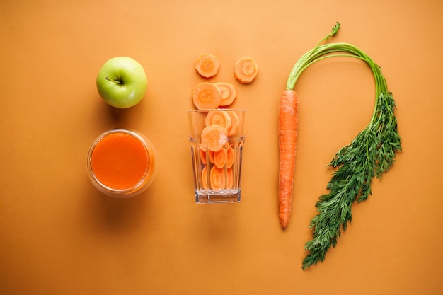 Photo close up on composition with ripe fresh carrots, juice and slices