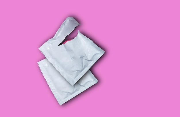 Photo close-up of condom packet on pink background