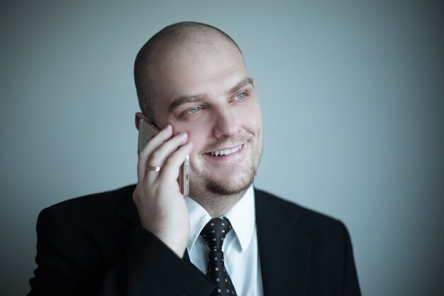 Close up.confident businessman in a tie listens to the interlocutor on the phone.