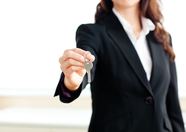 Close-up of a confident businesswoman holding a key