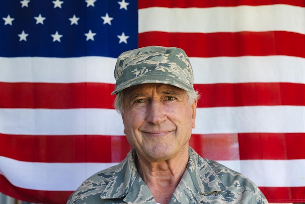 Close-up of confident caucasian army soldier wearing camouflage clothing against flag of america