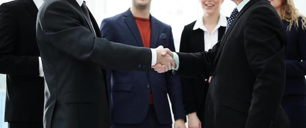 Close up confident handshake of business people