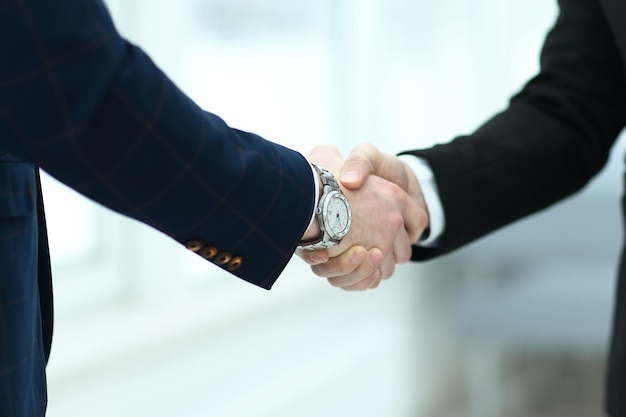 Close up confident handshake of business people