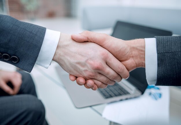 Close up confident handshake of financial partners