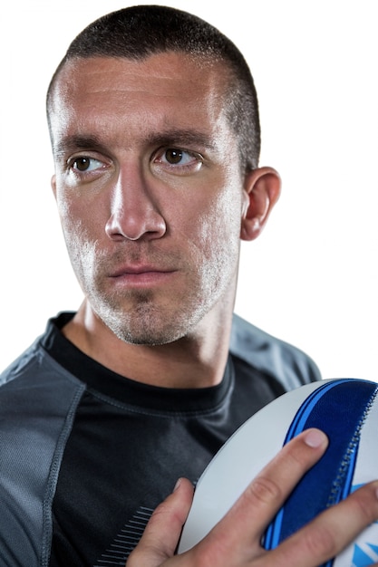 Close-up of confident rugby player holding ball