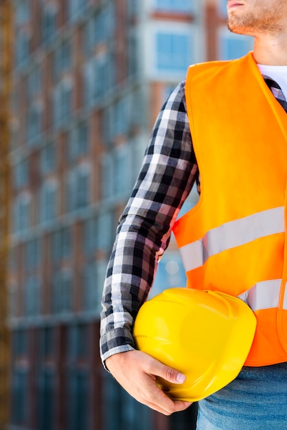 Close-up construction engineer holding helmet