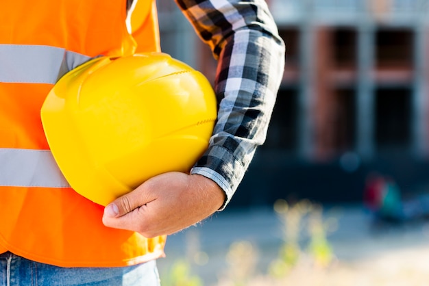 Close-up construction worker holding helmet