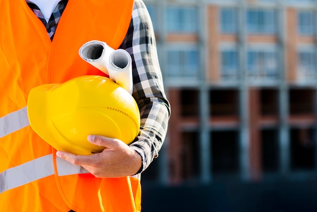 Close-up construction worker holding helmet