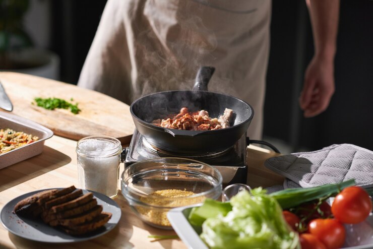 Photo 밥솥 근처에 서서 냄비에 야채와 함께 고기를 튀기는 요리사의 근접
