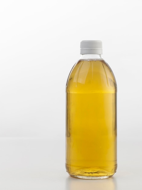 Photo close-up of cooking oil in bottle against white background