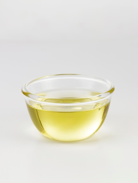 Photo close-up of cooking oil in bowl over white background