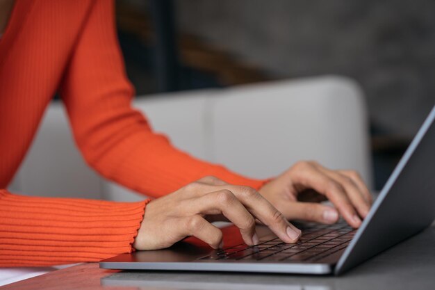 Close up of copywriter hands using laptop computer typing working freelance project from home