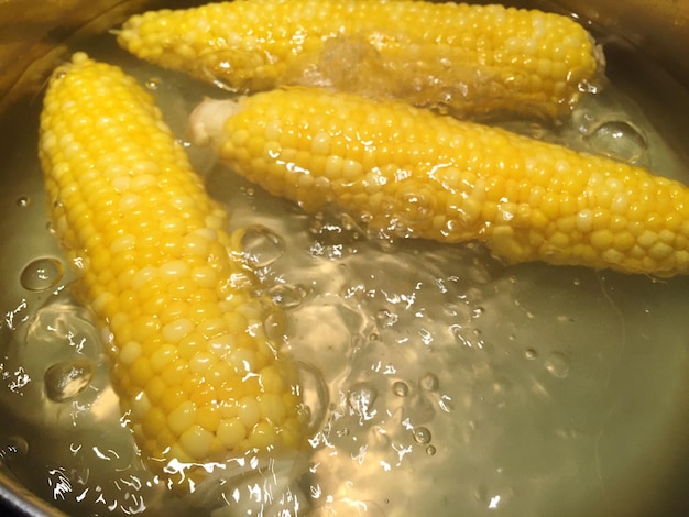 Close-up of corn on the cob boiling in saucepan