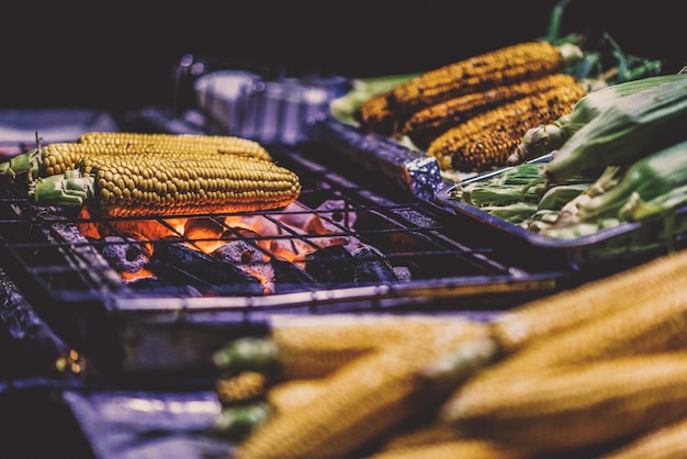 Photo close-up of corns being cooked on barbecue grill