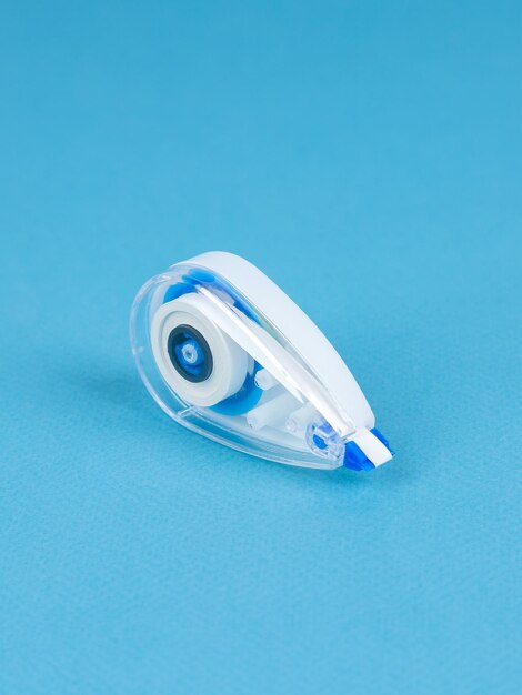 Close up of the correction tape isolated on blue background Image of a correction tape