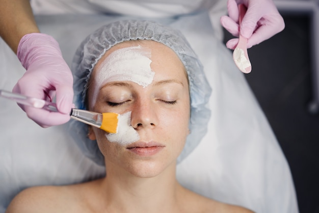 Крупный план косметолога, положить маску с помощью кисти