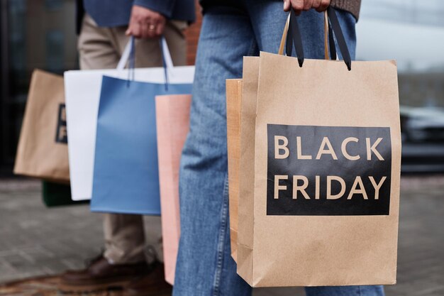 Primo piano di una coppia che tiene le borse della spesa del black friday