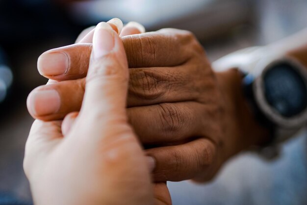 Photo close-up of couple holding hand indoors