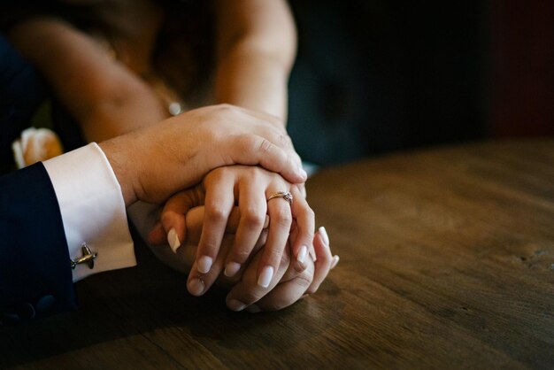 Photo close-up of couple holding hands on table