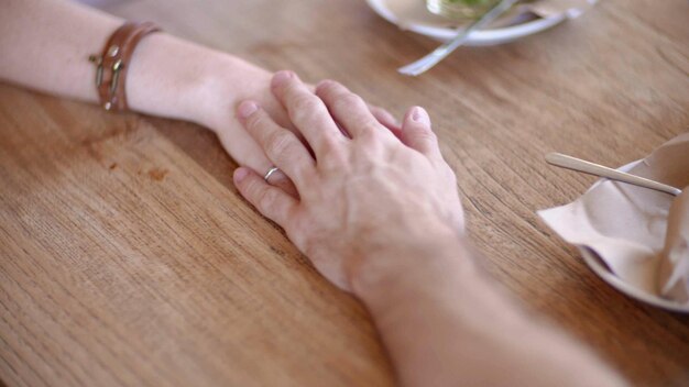 Close up of couple in love holding hands in cafe