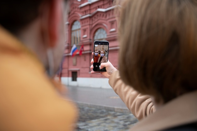 Chiuda sulle coppie che prendono selfie in città