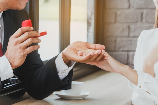 Photo close-up of couple with wedding ring at table