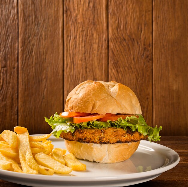 Primo piano su hamburger di pollo croccante con lattuga e pomodoro.