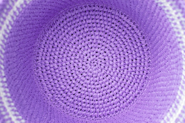 Close up of a crochet summer raffia hat with lavender\
color