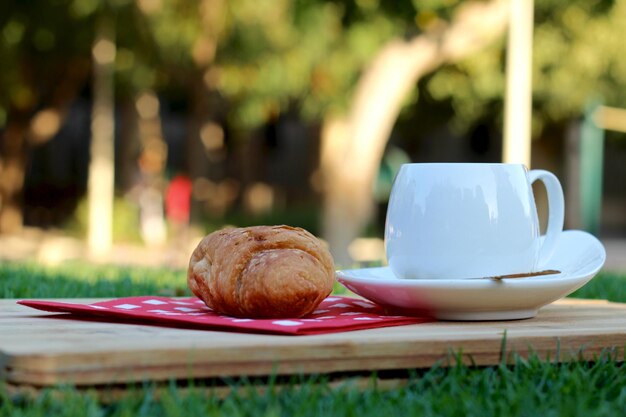 Foto close-up di un croissant e una tazza di tè su un tavolo da taglio