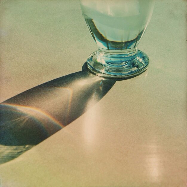 Photo close-up of a cropped glass with reflection of table