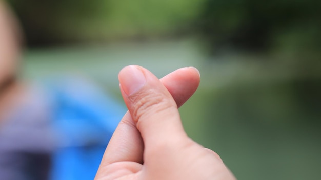 Close-up of cropped hand gesturing at outdoors