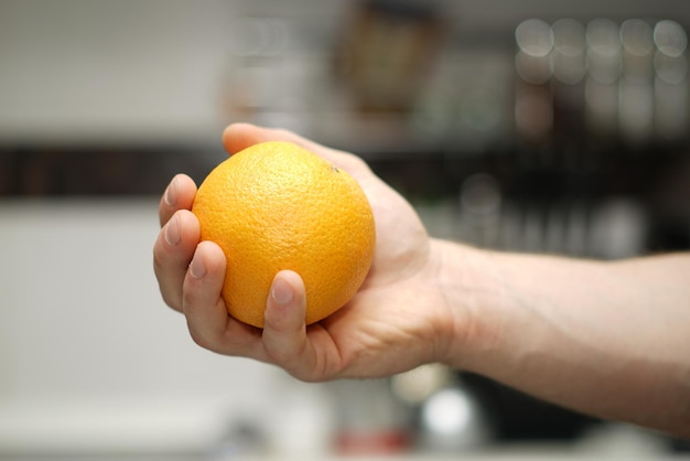 Close-up of cropped hand holding orange