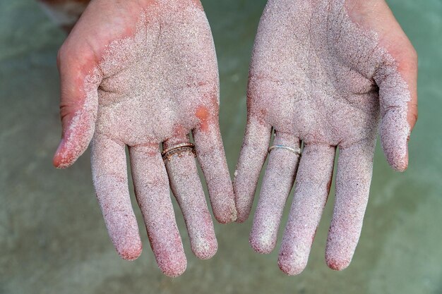 Photo close-up of cropped hands with sand