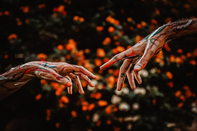 Close-up of cropped painted hands against trees