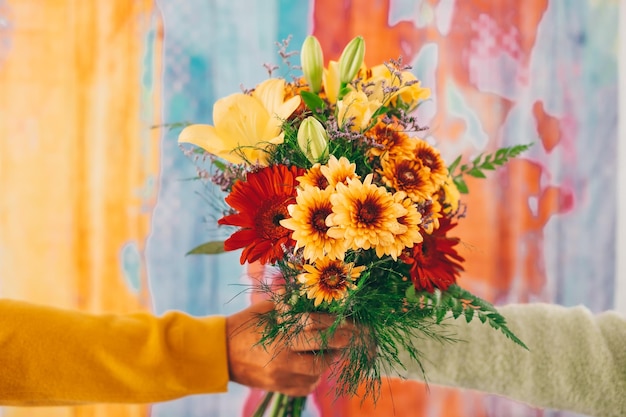 Photo close up cropped photo of female and male hands holding a bouquet of flowers