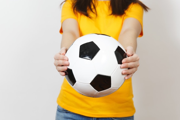 Close up cropped portrait european young woman, football fan or\
player in yellow uniform holding soccer ball isolated on white\
background. sport, play football, health, healthy lifestyle\
concept.