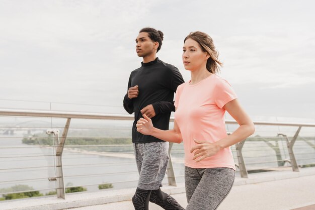 Close up cropped portrait of fit young romantic couple athletes\
man and woman jogging running