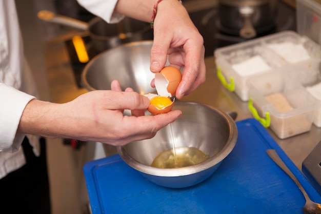 Close up cropped shot of unrecognizable chef cracking an egg open