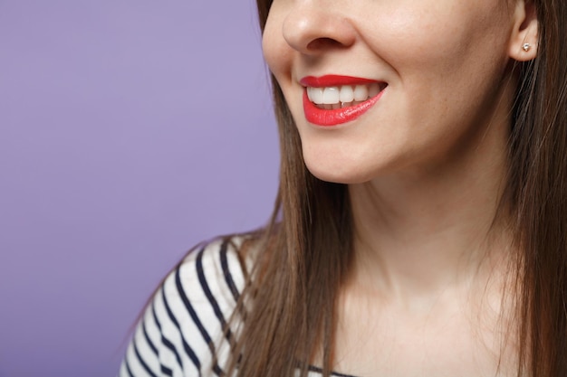 Close up cropped smiling woman girl with clean skin, red sensual lips white health even straight teeth isolated on violet purple background. healthcare cosmetic procedures concept. mock up copy space