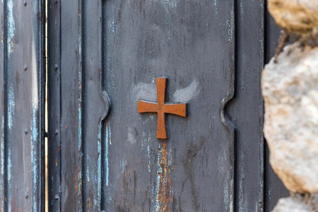 Close-up of cross on metal door