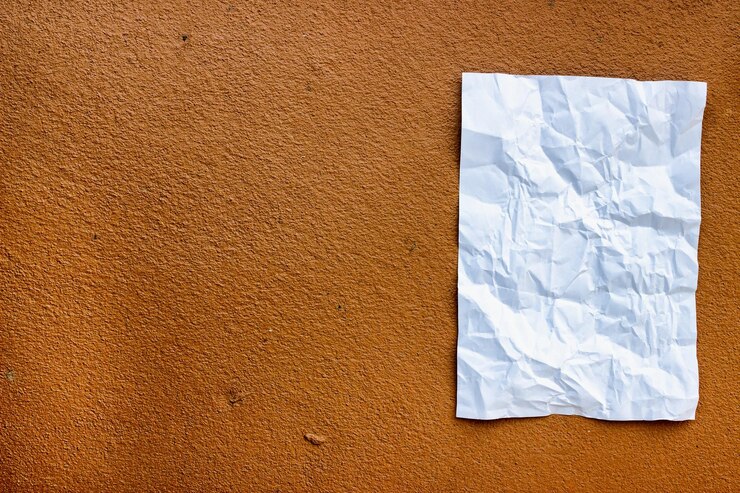 फोटो close-up of crumpled paper against brown wall