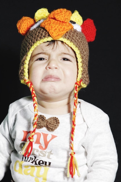 Foto close-up di un bambino che piange su uno sfondo nero