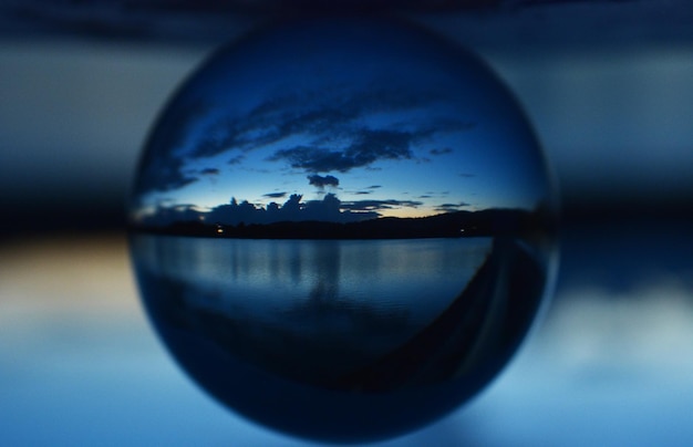 Foto close-up di una palla di cristallo contro il mare durante il tramonto